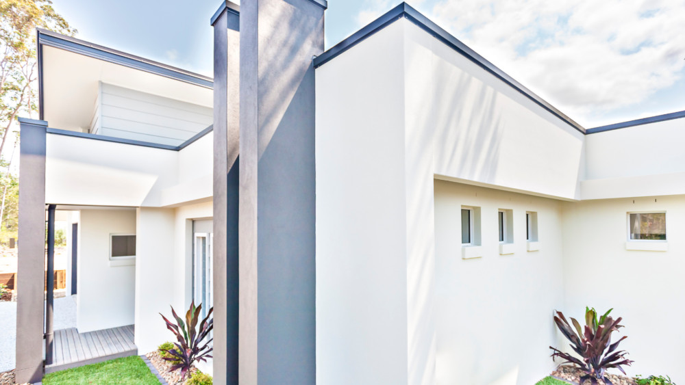 The exterior of a home painted white, with blue trim.