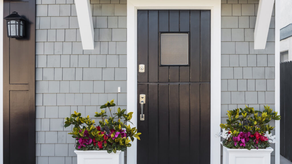 A black door in a gray painted home exterior.