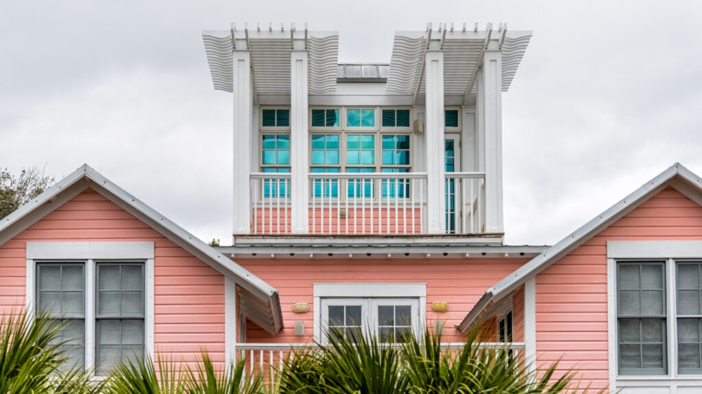 The exterior of a house painted pale pink with white trim.