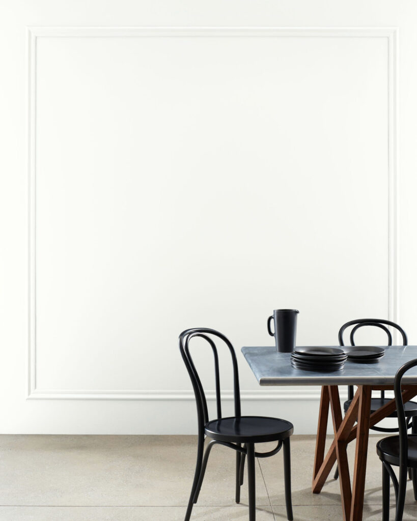 A white dining room wall with white trim.